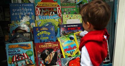 Un niño elige un libro en la Feria del Libro de Madrid.