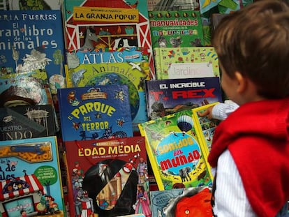 Un niño elige un libro en la Feria del Libro de Madrid.