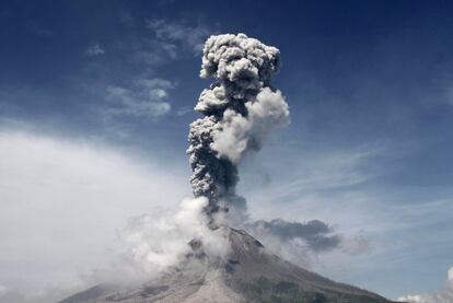 El volcán Monte Sinabung, activo desde 2010, arroja humo y cenizas al aire durante una erupción, visto desde Sukandebi (Indonesia).