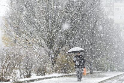 Un hombre se resguarda de la nieve en Vitoria (Álava).
