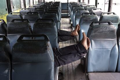  Dos conductores se echan una siesta en un autobús que permanece fuera de servicio con motivo del cese de actividades por las protestas contra la supuesta profanación de una copia del libro sagrado sij, en Amritsar (India), hoy, 19 de octubre de 2015.