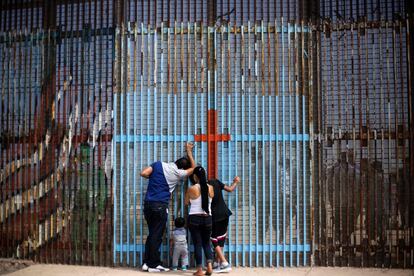 Uma família conversa com parentes através da cerca da fronteira entre o México e os Estados Unidos em Tijuana (México), em 2 de julho de 2016.