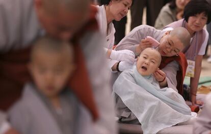 Monjes budistas rapan la cabeza a un grupo de niños durante una ceremonia que los convertirá en futuros monjes en el templo Chogye de Seúl (Corea del Sur).