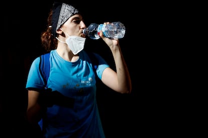 Una voluntaria bebe agua embotellada en Catarroja (Valencia), este domingo.