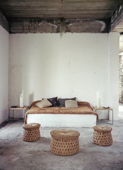 A la izquierda, paredes de cal, techos de hormigón y suelos de cemento sin pulir. La espartana habitación cuenta con una cama con base de hormigón y taburetes de la firma mexicana Txt.ure.