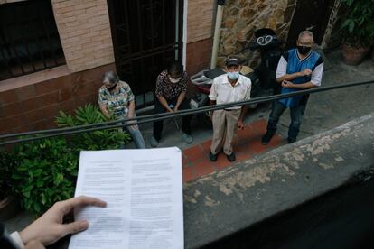 Joshua De Freitas, de El Bus TV, lee noticias con un micrófono a los vecinos del barrio Campo Bello. En medio de la pandemia, esta organización logra llevar información a ocho ciudades de Venezuela para atender a parte del grueso de desconectados de un país donde solo cuatro de cada 10 personas tiene una línea de móvil.