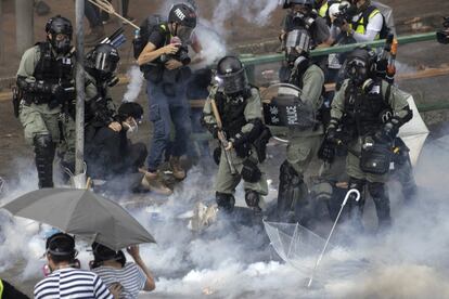 Agentes de la policía antidisturbios detienen a un manifestante durante las protestas.intentaban romper un cordón policial. eso está atrapando a cientos de ellos en un campus universitario. (Foto AP / Ng Han Guan)