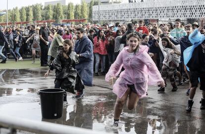 Asistentes al Festival Mad Cool corren tras las intensas lluvias de este jueves en la capital.