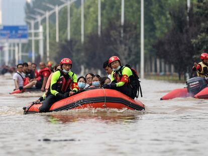 Bomberos evacúan en lanchas a residentes de Zhengzhou, capital de la provincia china de Henan el 22 de julio de 2021.