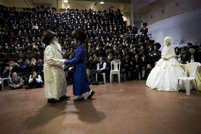 An ultra-Orthodox Jewish bride enters to the men's section of the wedding, to fulfill the Mitzvah tantz, in which family members and honored rabbis are invited to dance in front of the bride, often holding a gartel, and then dancing with the groom, during her wedding to the grandson of the Rabbi of the Tzanz Hasidic dynasty community, in Netanya, Israel,in Netanya, Israel, Wednesday, March 16, 2016. (AP Photo/Oded Balilty) 