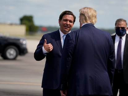 Ron DeSantis habla con Donald Trump (de espaldas) en el aeropuerto de Fort Myers, en Florida, en octubre de 2020, semanas antes de las últimas elecciones presidenciales.