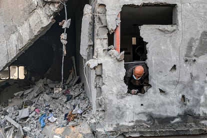 Un hombre observa a través de un agujero de un edificio afectado por un bombardeo en Jan Yunis, en el sur de la franja de Gaza, este miércoles.