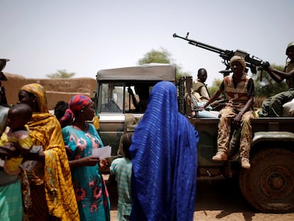 Soldados del ejército de Malí pasan junto a un grupo de mujeres y niños durante una operación en Nadki el 29 de julio de 2019.