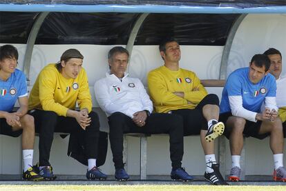 El actual técnico del Inter, Jose Mourinho, rodeado de sus jugadores, prueba el banquillo del campo donde entrena el Madrid, su posible equipo la próxima temporada.