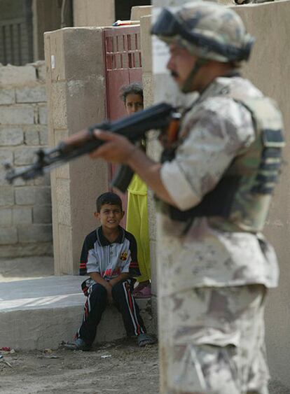 Dos niños miran a un soldado iraquí en Yusufiya (sur de Bagdad).