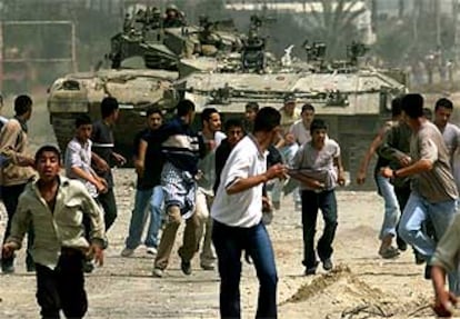 Jóvenes palestinos corren ante el avance de los blindados israelíes al sur de la franja de Gaza.