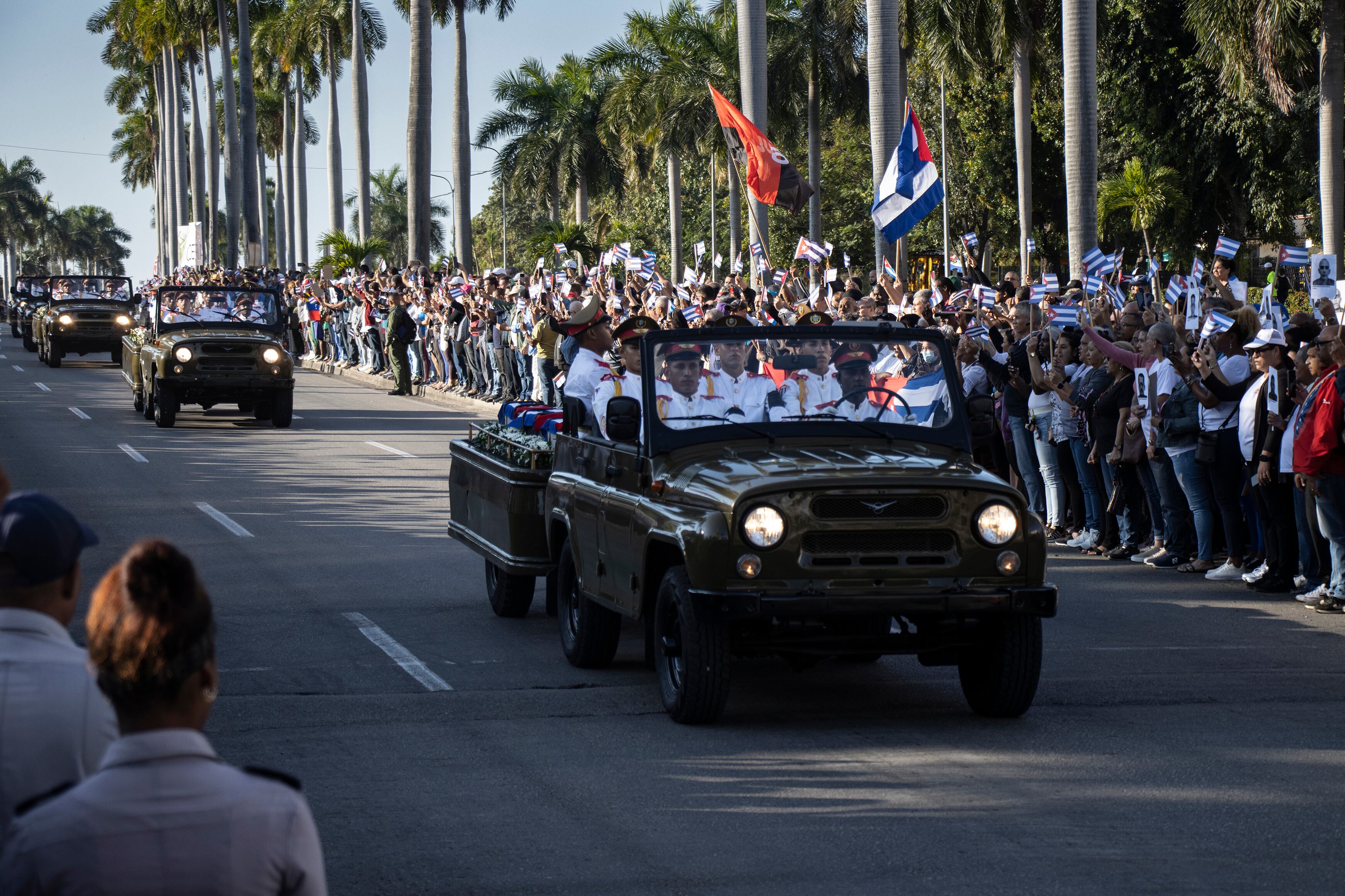 Personas observan una caravana fúnebre que transporta a los 32 militares, en La Habana, este jueves.