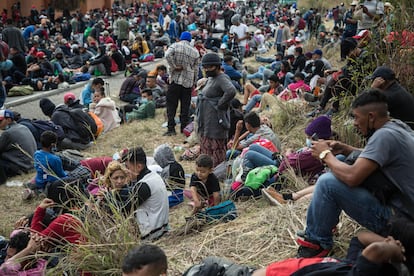 Varios migrantes hondureños descansan en una carretera después de que el ejército guatemalteco detuviera su paso.