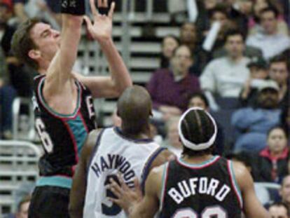 Gasol se eleva sobre Haywodd y su compañero Budford para lanzar a canasta.