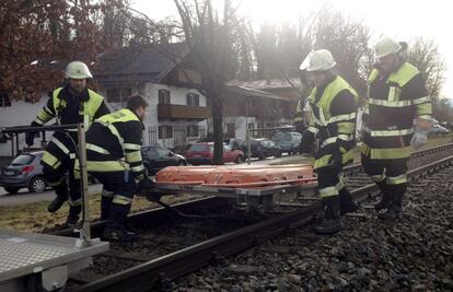 Bomberos trabajan en el lugar donde se ha producido el choque de dos trenes en Bad Aibling (Alemania).