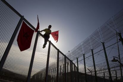 Un muchacho retira ayer las banderas marroquíes colocadas en la frontera.