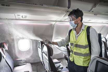 Un operario de Iberia desinfecta una cabina tras la llegada de uno de sus aviones desde América. Los trabajos de limpieza se han reforzado y perfeccionado según los procedimientos sanitarios internacionales.