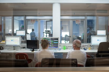 Dos celadores, sentados en el mostrador de la UCI del hospital de Teruel.