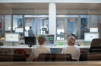 Dos celadores, sentados en el mostrador de la UCI del hospital de Teruel.


