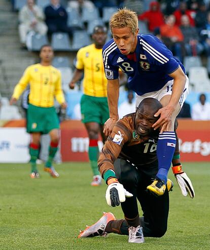 El delantero  Keisuke Honda se sube sobre la espalda del cancerbero camerunés Hamidou Souleymanou.