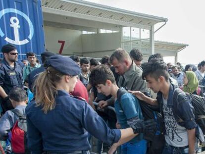 Refugiados pasan un control policial en Austria a su llegada desde Hungr&iacute;a. 