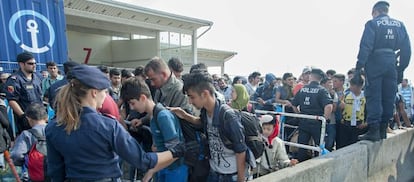 Refugiados pasan un control policial en Austria a su llegada desde Hungr&iacute;a. 