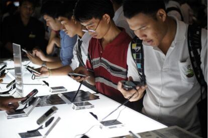 Visitantes en una feria de tecnología de Bangkok prueban dispositivos Blackberry.