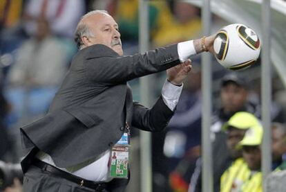 Del Bosque intenta atrapar el balón desde el banquillo.