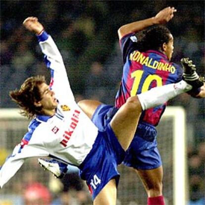 Ronaldinho salta por un balón, en una acrobática jugada, con el zargozista Ponzio.