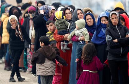 Mujeres migrantes con sus hijos hacen cola para recibir alimentos, en el punto fronterizo de Pazarkule (Turquía).