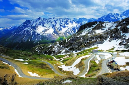 La carretera asciende por la vertiente sur del Galibier, con el macizo des Écrins al fondo. Este puerto tiene pasado contrabandista: durante el siglo XIX los traficantes se beneficiaban de la diferencia en el precio de la sal entre Francia, al norte, y Saboya, al sur.