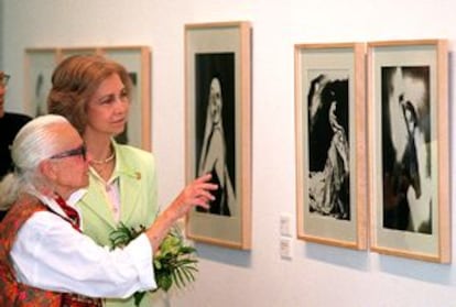 La reina Sofía atiende las explicaciones de Lillian Bassman sobre sus fotografías expuestas en el Real Jardín Botánico de Madrid.