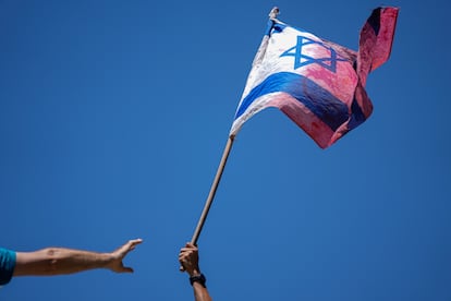 A demonstrator waves a colored Israeli flag during a protest against plans by Prime Minister Benjamin Netanyahu's government