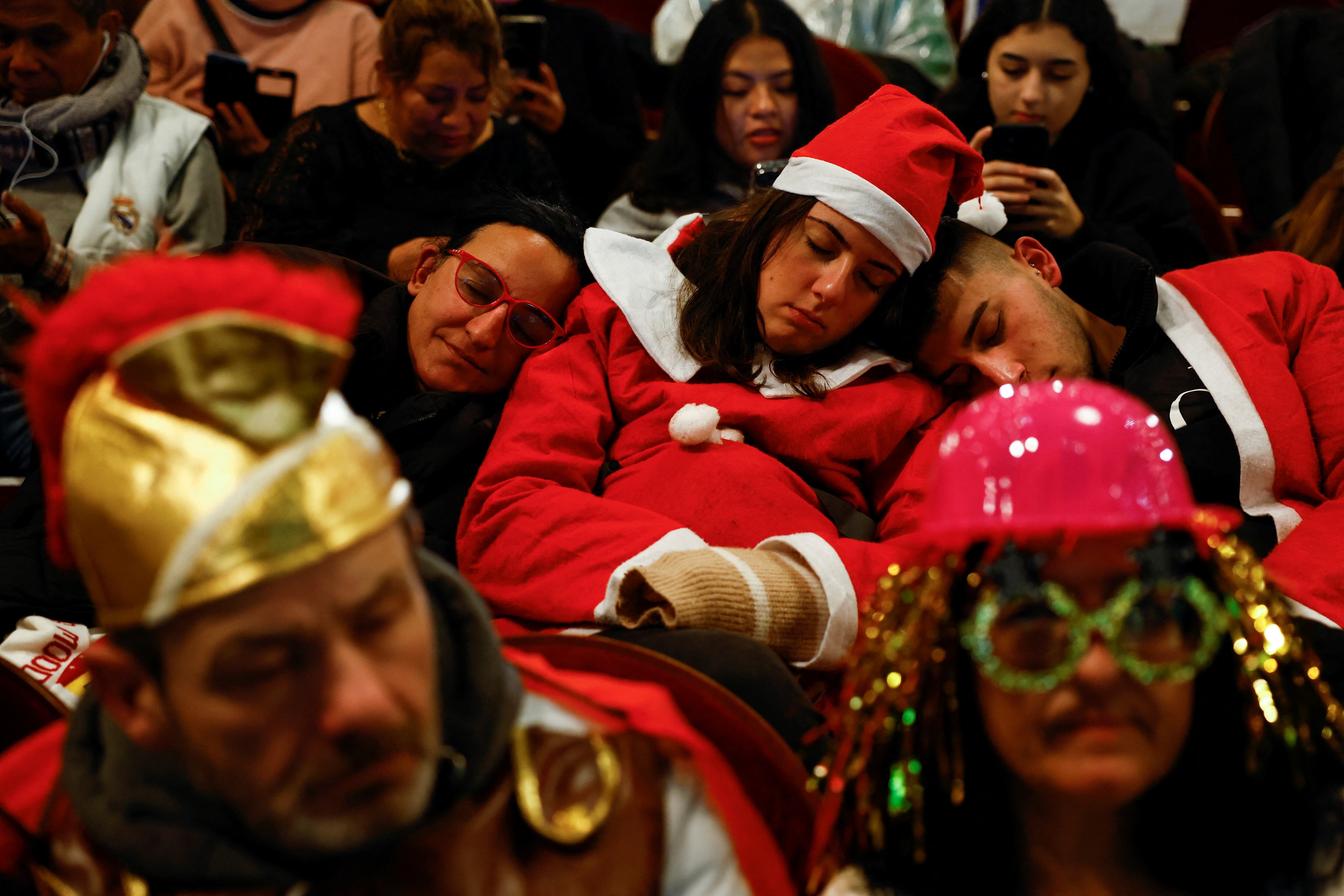 Asistentes al sorteo echan una cabezada, a la espera del inicio del sorteo de Navidad, este viernes.