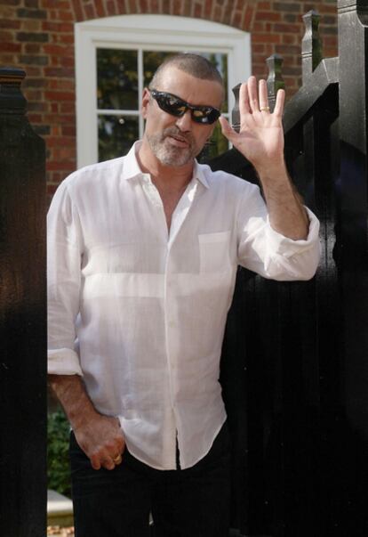 George Michael saluda a los fotógrafos desde su casa en Highgate, Londres, el 11 de octubre de 2010, tras pasar cuatro semanas en prisión