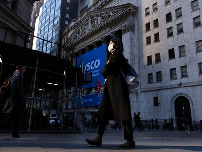 Una persona protegida con una máscara camina este lunes frente a la Bolsa de Nueva York.