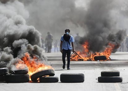 Um manifestante caminha entre barricadas em Managua.