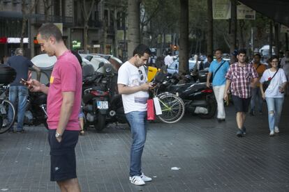 Dos hombres parados en medio de la calle consultan el teléfono.