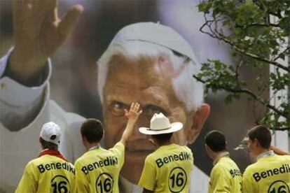 Participantes de la Jornada Mundial de la Juventud en la ciudad alemana de Colonia observan un cartel con la imagen del Papa.