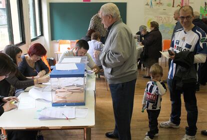 Decenas de votantes hacen colas en los distintos colegios electorales del País Vasco. En la imagen, un padre y un hijo guardan cola antes de ir al partido de la Real Sociedad.
