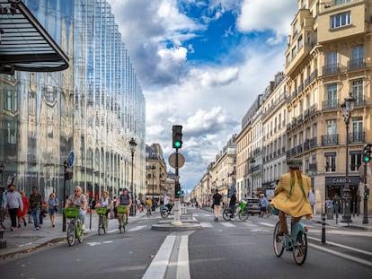 Varias personas circulan en bicicleta por el amplio carril bici de la calle Rivoli, en el centro de París.
