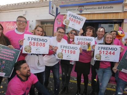 Varios trabajadores se reúnen a las puertas de la administración de lotería El Perolo, en San Pedro del Pinatar (Murcia).