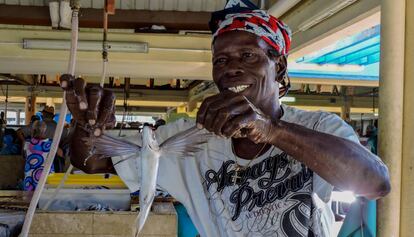 Un pescador de Barbados sostiene un pez volador.