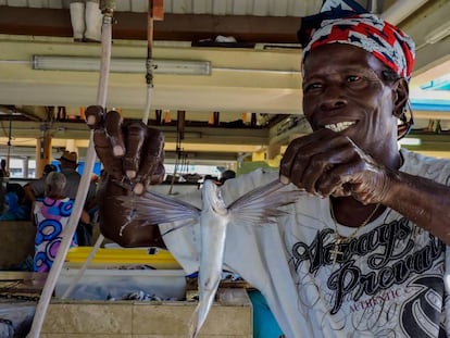 Un pescador de Barbados sostiene un pez volador.