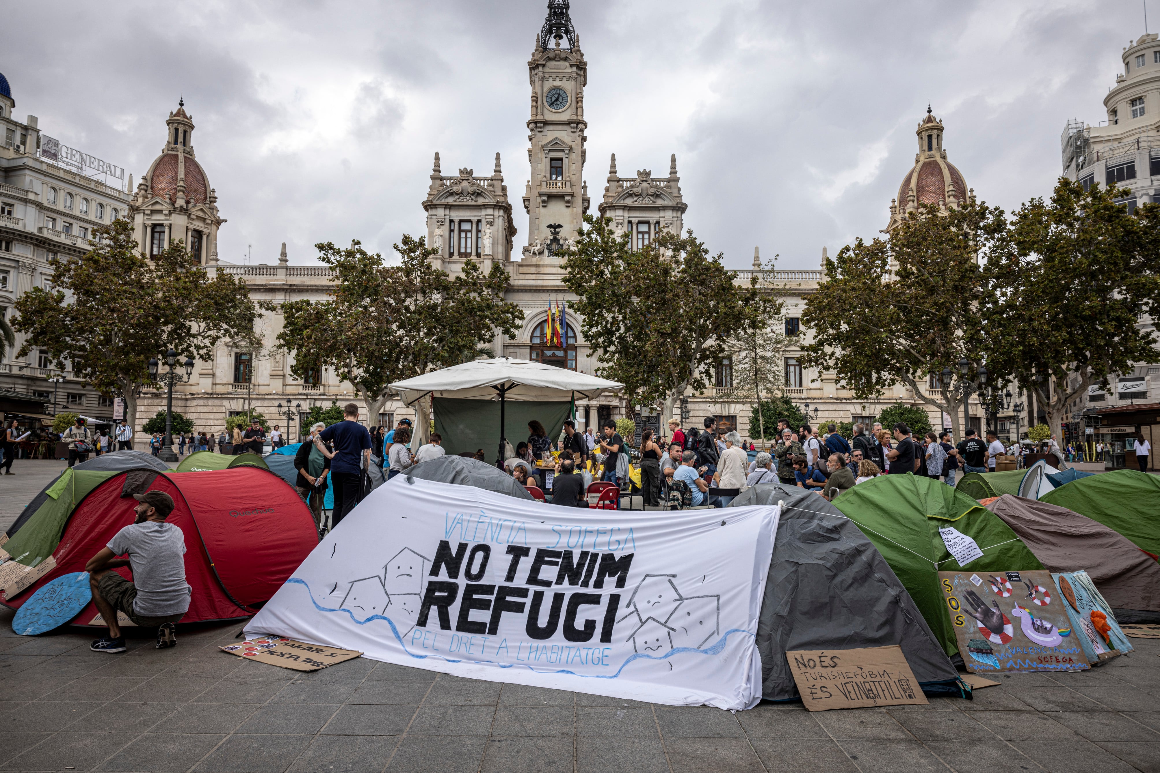 Decenas de personas acampadas en la plaza del Ayuntamiento de Valencia para reclamar el derecho a una vivienda digna y denunciar la especulación.